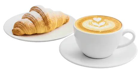 Un cappuccino e un croissant su due piattini bianchi da bar